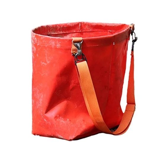 Eine robuste rote Pflanztasche mit einem orangefarbenen Schultergurt, ideal zum Transport von Setzlingen bei Wiederaufforstungsarbeiten.