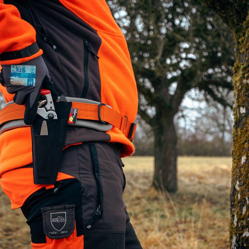 Tasche für Gartenschere – Baumpfleger schneidet Ast beim Baumschnitt mit Schere und Forstgürtel.